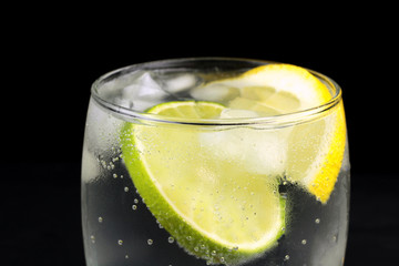 Mineral water in the glass with lime and lemon slices