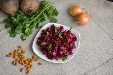 Vegetable salad with red beans, beet, cucumber, onion and butter on a plate on the table