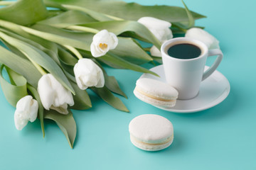 Fototapeta na wymiar Breakfast with coffee cup and white tulips on plain background