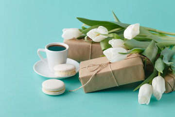 Breakfast with coffee cup and white tulips on plain background