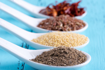 Detail view of four spoons containing asian ingredients, selective focus