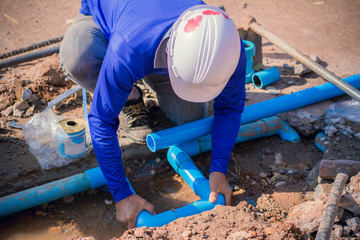 Construction worker,Repairing a broken water pipe on the concrete road.