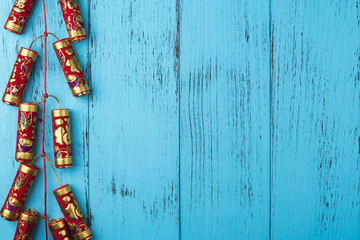 Chinese New Year decoration: firecrackers on weathered blue wooden planks, copy space, overhead - obrazy, fototapety, plakaty