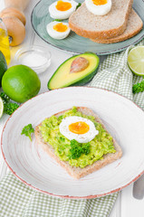 Sandwich with whole grain bread, mashed avocado and boiled eggs