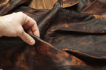 Tailor produces cutting brown leather for the manufacture of products.