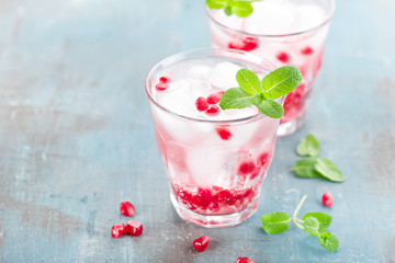 Infused water made of fresh pomegranate and mineral water with ice, cold refreshing and detox drink