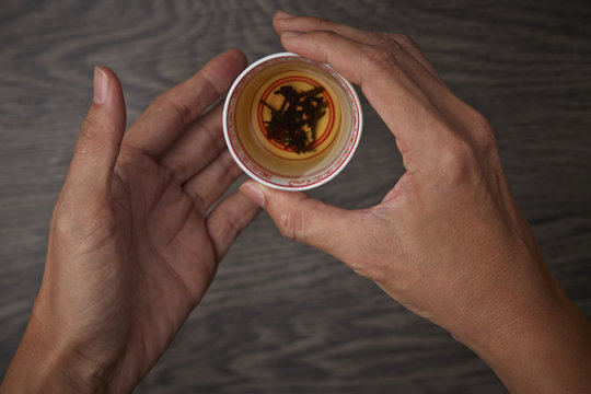 Traditional tea ceremony, man holding a cup of tea - Powered by Adobe