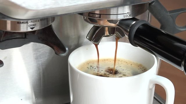 coffee machine pouring espresso in cup