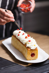 Female hands decorating cake