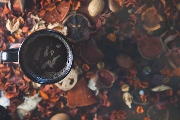 Top view of black mug of coffee with orange background copyspace