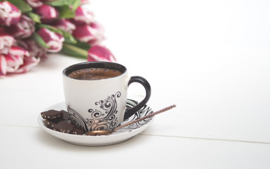 Obraz na płótnie Canvas coffee mug on white background and tulips