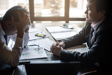Boss accusing upset man to making business failure in firm office.