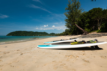 Two paddleboards lying on sand beach, sea in background