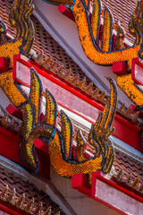 Fototapeta premium Traditional Thai temple roof details. Wat Mongkol Nimit temple in Phuket town, southern Thailand.