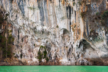 Limestone rock texture above clear blue water. Mountains in Khao Sok national park, Cheo Lan lake, Thailand