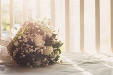 Beautiful white roses for wedding on white bed.