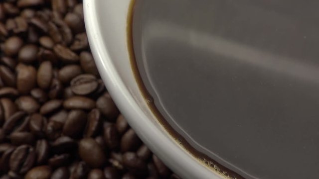 4k A cup of black coffee over Roasted Coffee Beans-Dan