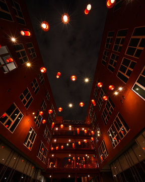 Illuminated lanterns in between buildings at night 
