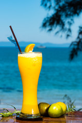 Fresh orange juice with ice in glass, frontal view