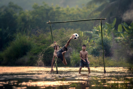 children play football on marshland