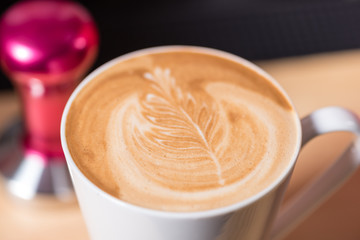 detail view of leaf drawn in cappuccino milk froth