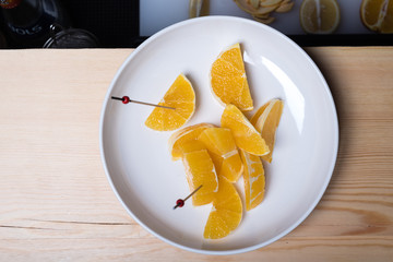 Skillfully peeled and sliced fresh oranges on white plate, top view