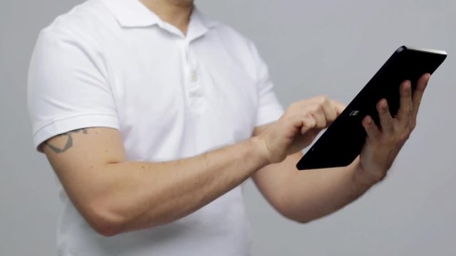 man with tablet pc over gray background
