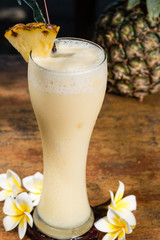 Pineapple milkshake in glass on table