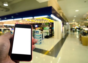 Smartphone in hand with blank screen isolated with space for copy on department store blurred background, business, technology and advertise concept, color tone effect.