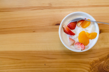 Yogult with Strawberry and Mandarin Orange on Wood background.  Yogult is a good food for who want to diet and good for your health.