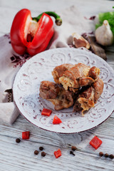 charcuterie, meat, baked pork rolls with egg omelet, Bulgarian red pepper, spice and lettuce on a wooden white background 