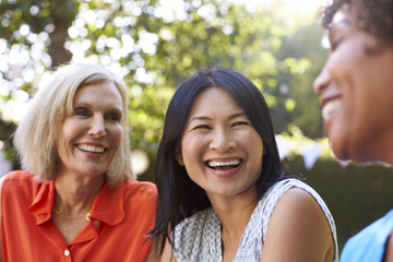 Mature Female Friends Socializing In Backyard Together - Powered by Adobe