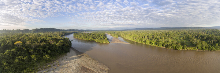Aerial panorama of the Rio Napo in the Ecuadorian Amazon surrounded  by pristine rainforest  illuminated by the morning sun.
