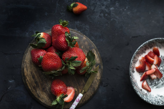 Overhead view of fresh strawberries on wooden cutting board