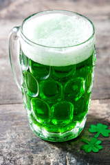 Traditional cold green beer on wooden table for Saint Patrick's Day. Copyspace.