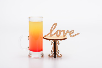 alcohol cocktail in glass on little decorative table, love inscription