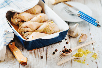 meat for dinner, baked chicken legs with spices, pepper and fresh white bread on wooden background 