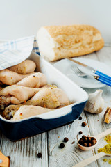 meat for dinner, baked chicken legs with spices, pepper and fresh white bread on wooden background 