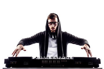 Young stylish man in glasses posing behind mixing console on white studio background.