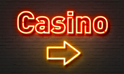 Casino neon sign on brick wall background.
