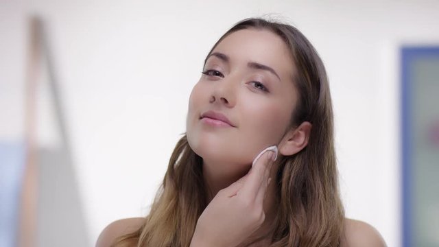 Young attractive woman removes makeup