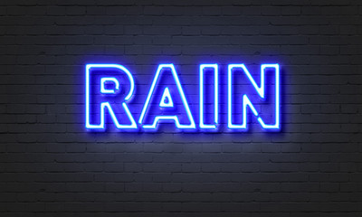 Rain neon sign on brick wall background.