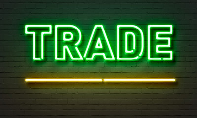 Trade neon sign on brick wall background.