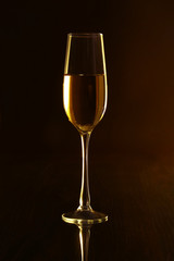 Glasses with white wine on black mirror table. Celebrities composition.