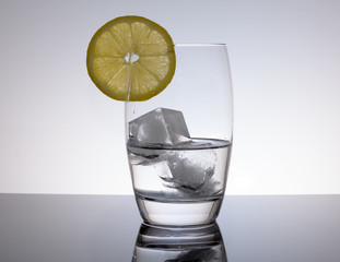 Wasser mit Zitrone als Erfrischungsgetränk vor weissem Hintergrund