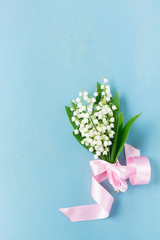 Bouquet of Lilly of the valley fresh flowers on blue wooden background with copy space