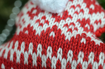 Close-up of red and white soft knitted woolen fabric with motives