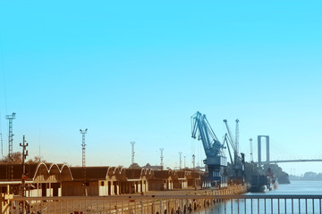 Fototapeta na wymiar Harbour crane and warehouse buildings