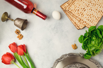 Passover holiday concept seder plate, matzoh and wine bottle on bright background. Top view from above