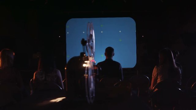 People are watching a movie on an old projector